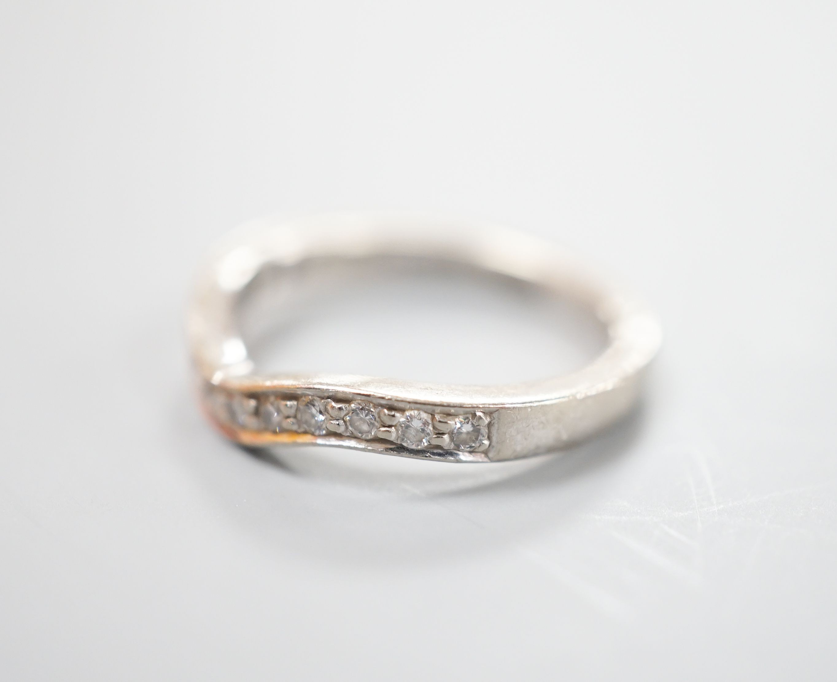 A modern 18ct white gold and diamond set shaped half eternity ring, size H/I, gross weight 3.3 grams.